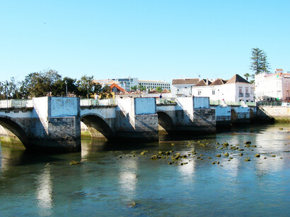 Los días en Tavira amanecen pronto. El sol sale a eso de las 6 de la mañana. Puente Antiguo (Puente Romano) sobre el río Golao, Tavira, Algarve, Portugal