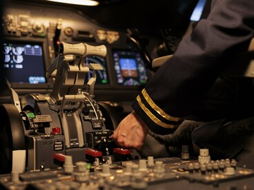 Close-up of a pilot working the aircraft’s flight controls, reflecting the importance of human judgment in high-stakes technological environments