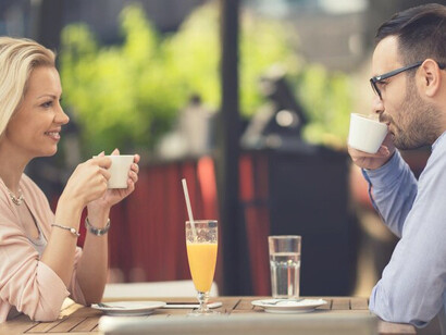 The embodiment of love and connection as a joyful couple converses over coffee in a cozy café, reflecting empowerment and fulfilling expectations in relationships