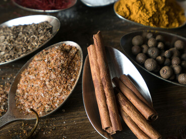 Spices and herbs on wooden spoons, reflecting Caucasian herbal remedies and traditional medicine
