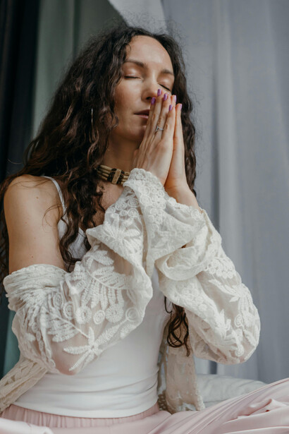 A serene woman practices meditation indoors, embracing mindfulness and wellness as part of her calm morning routine at home