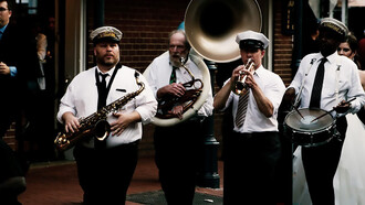 A vibrant crowd listening to musicians perform at a street festival in New Orleans, USA