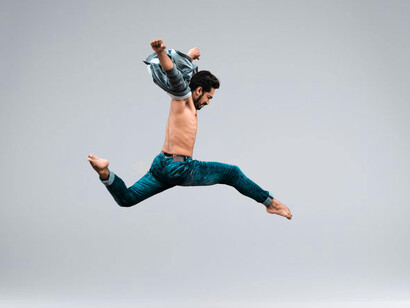 A man mid-air in a ballet pose