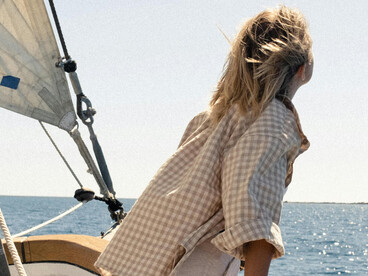 Rear view of a woman aboard a yacht, enjoying a luxury sailing trip across the Adriatic