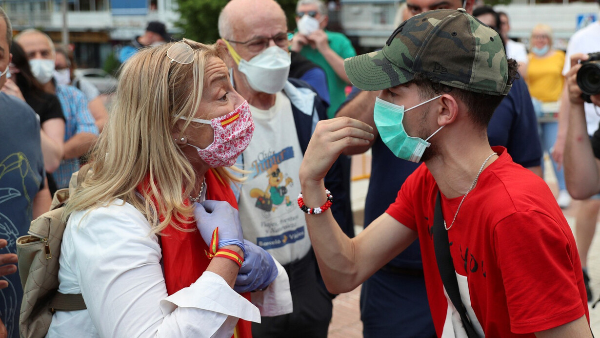 Un par de manifestantes con posiciones contrarias discuten la gestión del gobierno español