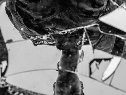 A man gazing into a mirror fractured into countless pieces, symbolizing the breakdown of confidence and certainty in a divided society