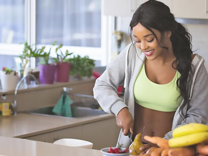 A joyful woman with a radiant smile preparing a wholesome and healthy meal
