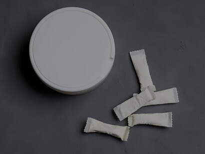 The striking imagery of snus nicotine pouches juxtaposed against a concrete backdrop, suggesting the allure of outer space while highlighting the risks of unhealthy addiction to these chewing nicotine bags