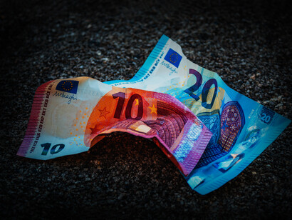 Un billete de 10 y 20 euros tirados en el suelo en representación de la perdida del poder adquisitivo de la moneda europea