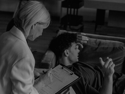 A therapist questions her male patient, and he turns his head away to question himself before answering