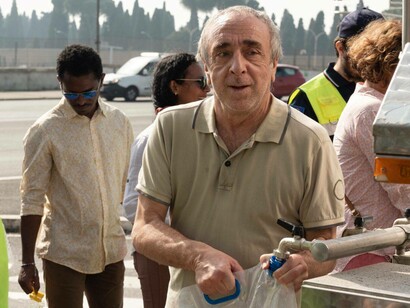 A scene where people are filling up their bags with water from the movie Siccità (2022)