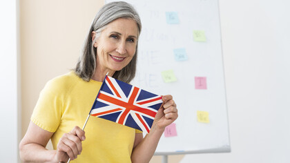 Female English teacher portrait holding an English flag