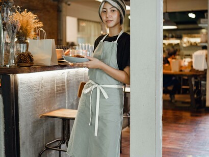 A waitress is about to offer customers their main meal in a hospitable manner