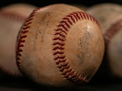 A worn-out baseball in focus, representing the emotion and support for the game