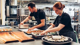 Chefes de cozinha preparam uma entrada para evento gastronômico