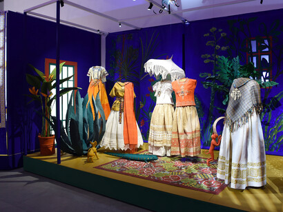 Vignette from the exhibition of Mirades de Murjeres featuring paper dresses and plants