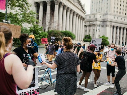 New York, United States. Protesters kneel while holding signs during a public demonstration
