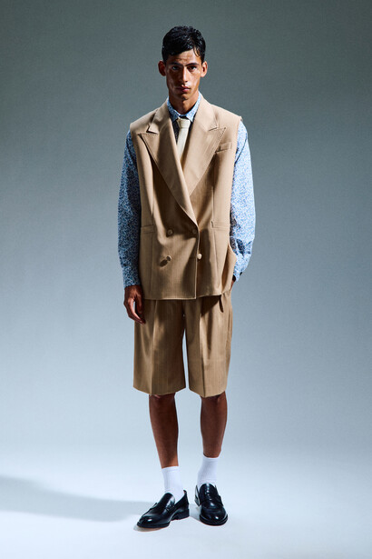 Un look  iconico della collezione: minimal e ben definito, composto da camicia 100% cotone stampa floreale, gilet oversize doppiopetto gessato, con rever a lancia, bermuda con pieghe per un fit over
