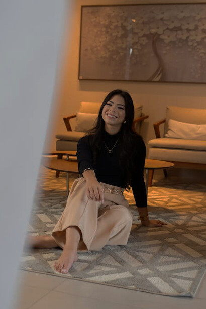 In a minimalist setting, a woman sits on the floor, enjoying the sleek lines and natural materials that define the space’s architectural design