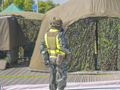 Swiss army soldier with protective suit at military training area at Swiss town