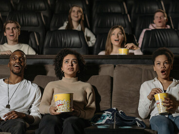 Audience members seated in a movie theater during a film screening