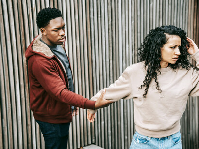 A woman appears upset while her partner grabs her hand, capturing control and conflict within the relationship