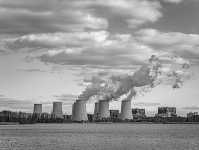 Smoke billowing into the sky illustrates the significant greenhouse gas emissions for which the U.S. is largely responsible, contributing to the climate change problem
