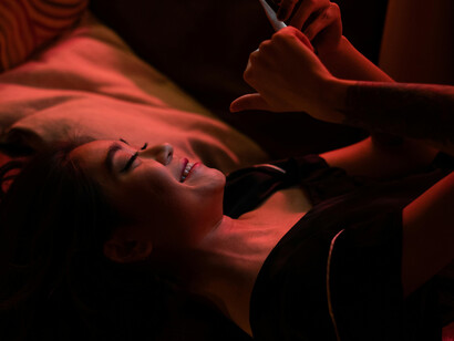A woman in bed looking at her phone—alone—capturing digital loneliness, millennial loneliness aesthetics, and isolation in the modern world