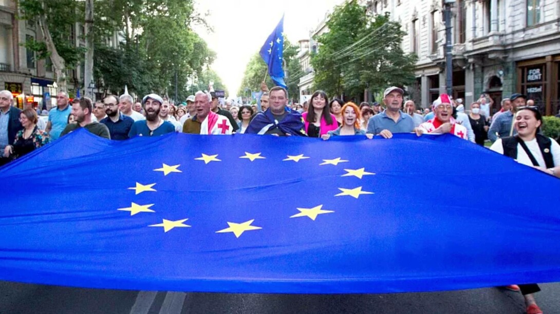 Demonstrators carry a giant EU flag during an anti-government rally near the Georgian Parliament in Tbilisi