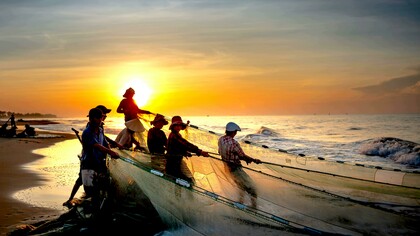 Jovens pescam com rede na praia