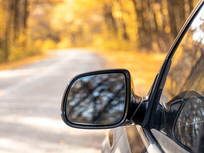 A rear view mirror offering a glimpse of the what we had to cross to reach where we are, symbolising the distance needed to see a situation differently