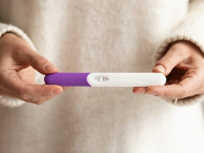A woman proudly displays a positive pregnancy test, symbolizing hope and new beginnings