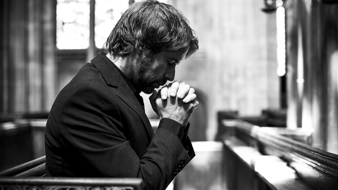 A solitary Christian man praying quietly in a church