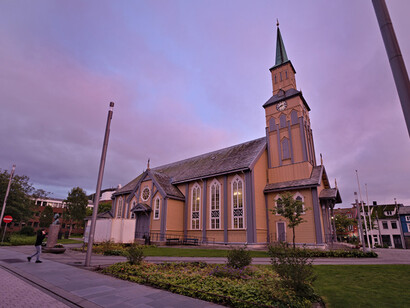 Dentro de la ciudad es posible apreciar las auroras boreales; el cielo se tiñe de tonos azulados y verdosos que iluminan la noche ártica Catedral de Tromsø, Noruega
