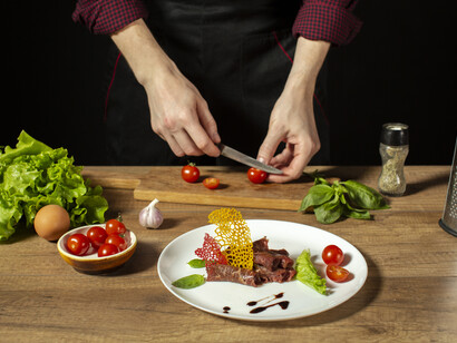 A person working with fresh ingredients in a kitchen, illustrating how global trade and local policy converge