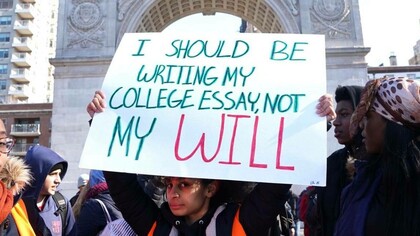 A young man holding up a pro-gun control sign 
