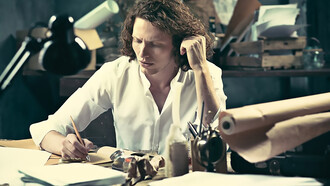 A young writer focused at home, sitting at the table and jotting down ideas in their sketchpad