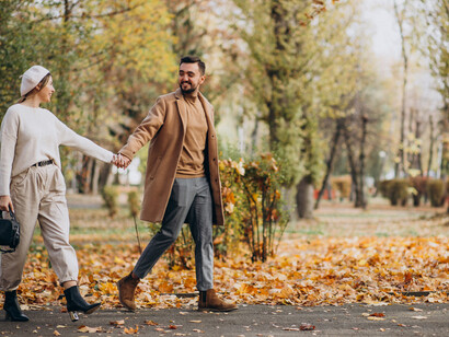 A young couple walking together through an autumn park, enjoying a quiet and natural moment