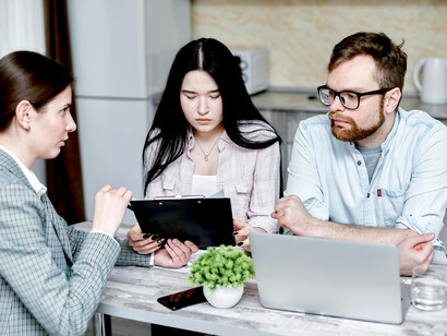 A family and a financial advisor reviewing notes together in a meeting to plan and decide their investments