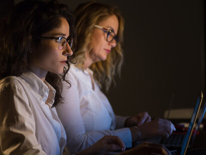 Colleagues collaborating on a project in a dark office with computer screens