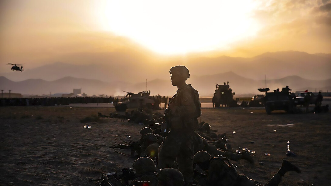 US Army 10th Mountain Division soldiers guarding the apron at Kabul Airport. Crowds of people can be seen in the background