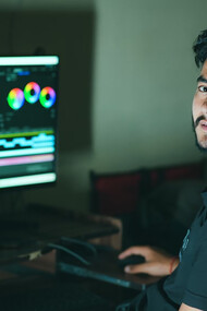 A man focused on editing content while working on his computer