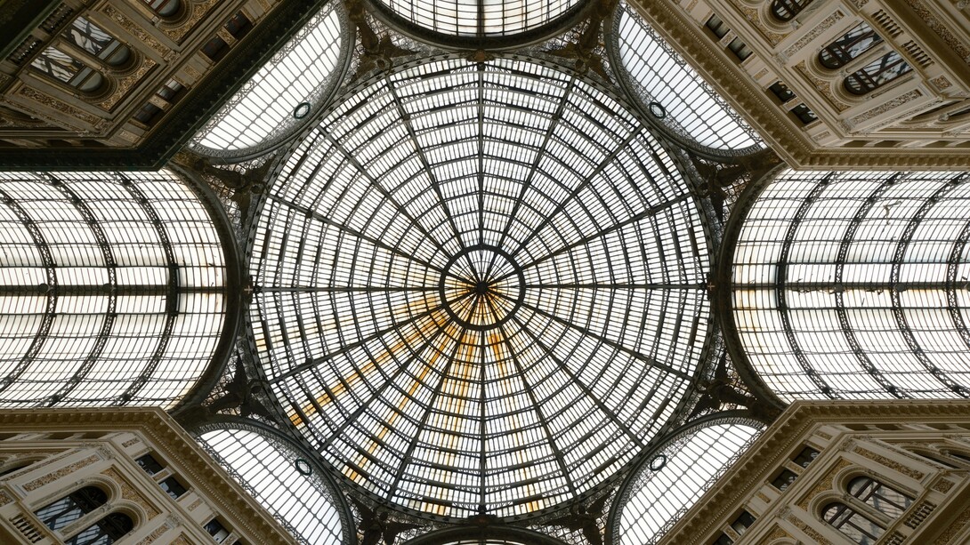 Nel centro storico di Napoli, l’intersezione tra l’eredità classica, le stratificazioni barocche e le pratiche informali genera un paesaggio urbano ibrido, dove la degeometria non cancella l’ordine, ma lo reinterpreta. Galleria Umberto I, Via Santa Brigida, Napoli, Italia