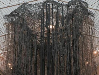 En el centro de la sala destaca una macro-propuesta inmersiva en forma de "penetrable" arbóreo y catedral boscosa de hilos negros, concebida como una cartografía viva, uterina y existencial que invita al espectador a adentrarse en ella. Fotografías por cortesía de Víctor Vega Valverde 