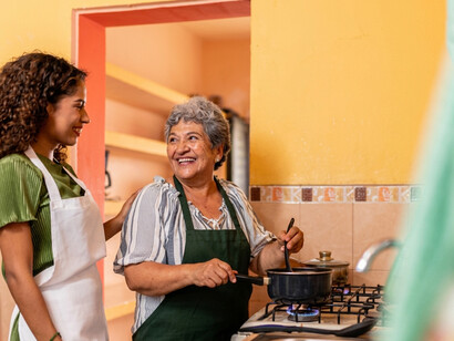 A young woman and her grandmother preparing a traditional meal together at home