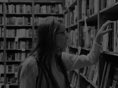 A university student in the library researching books for her thesis