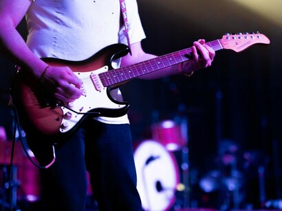 A guitarist performing live on stage during a rock concert