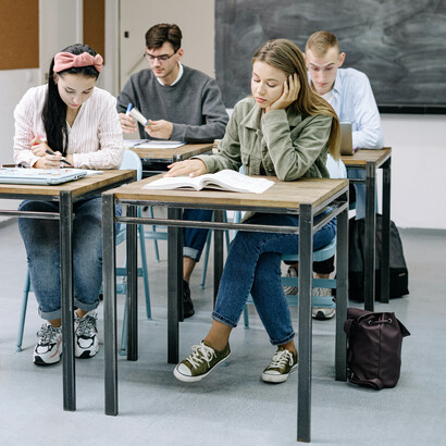 Alunos em sala de aula olhando para a ementa do ano letivo