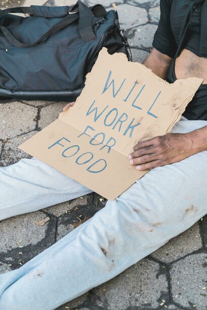 Homem mostra cartaz de 'Trabalho por comida'