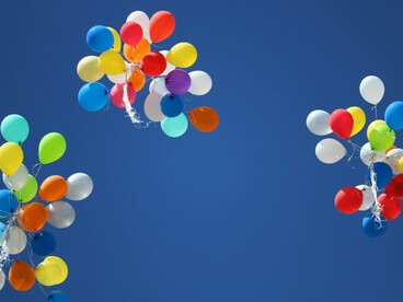 Trois lots de ballons s'envolant dans le ciel, représentant liberté et émancipation